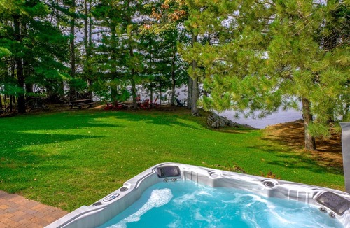 Spooner Cabin | Cozy Lake front luxury, hot tub, ice fish, snowmobile, fireplace, screened porch